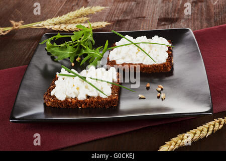 Dunkle Brotscheiben mit Hüttenkäse. Gesundes Frühstück. Stockfoto