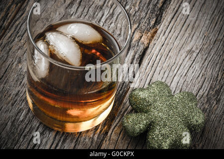 Glas Whiskey und Kleeblätter zum St. Patricks Day feiern Stockfoto