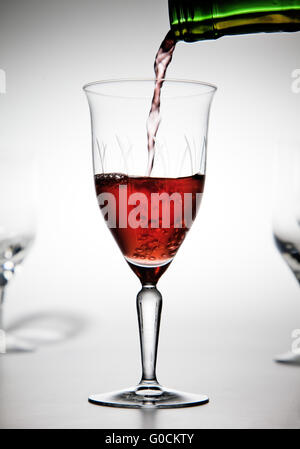 Rotwein wird in ein Weinglas gegossen Stockfoto