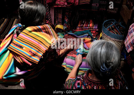 Frau, die Tzutes oder traditionelle Gebrauchstücher auf dem Markt von Chichicastenango verkauft, auch bekannt als Santo Tomas Chichicastenango, einer Stadt im Departement El Quiche in Guatemala, die für ihre traditionelle Kultur der Kiche Maya bekannt ist. Stockfoto