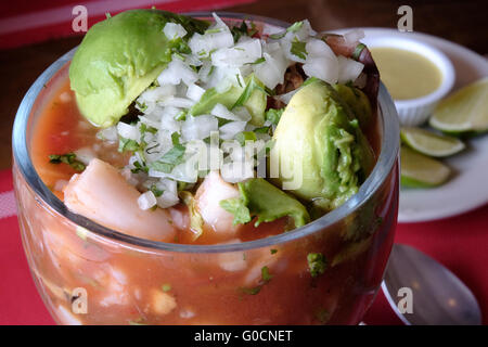 Guatemaltekische Ceviche mit Zwiebel und Avocado ein in den Küstenregionen Lateinamerikas beliebtes Fischgericht, das aus frischem rohen Fisch hergestellt wird, der in Zitrussäften mit Calamari-Zwiebeln und frischer Avocado gereicht wird. Stockfoto