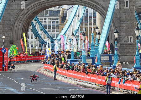 London Marathon 2016. Die Menschenmassen um die Tower Bridge unterstützen einen einsamen Rollstuhlfahrer Stockfoto