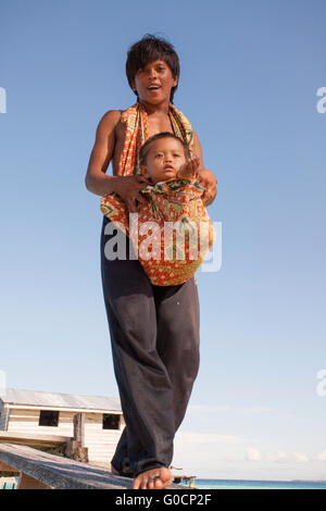 Porträt unbekannter junger Vater lokalen Bajau Suluk ethnische mit seinem Kind Pose für Kamera in Sibuan. Stockfoto