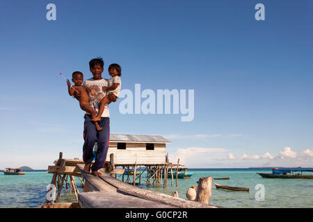 Porträt unbekannter junger Vater lokalen Bajau Suluk ethnische mit seinem Kind Pose für Kamera in Sibuan. Stockfoto