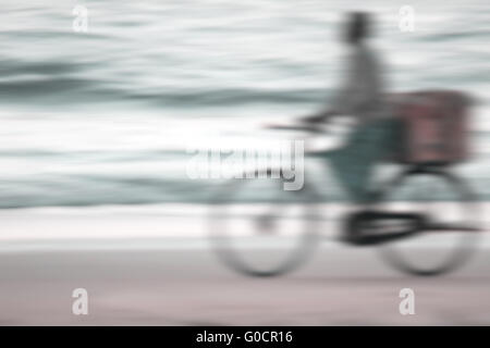 Indische Radfahrer am Strand in den Abend Licht w Stockfoto