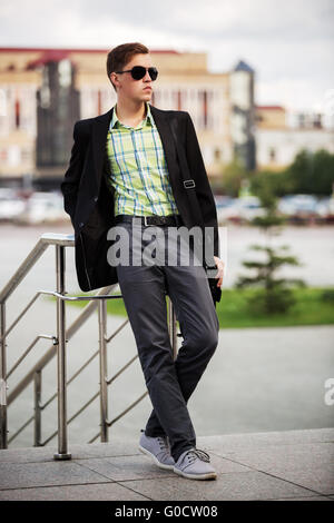 Junge Mode Mann mit Sonnenbrille auf der Stadtstraße Stockfoto