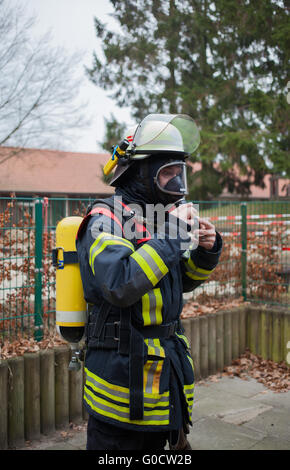 Feuerwehrmann schafft seine Atemwege schützende equ Stockfoto