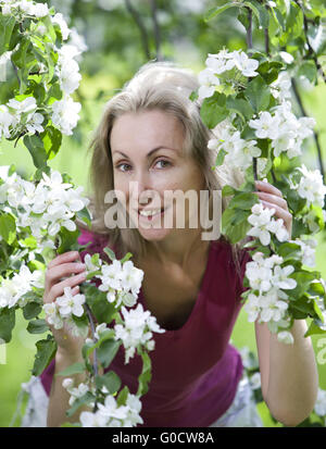 Frau stand in der Nähe des blühenden Apfelbaums. Stockfoto