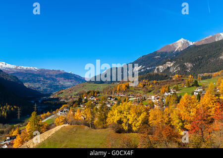 Schöne Aussicht auf das Dorf Filisur und die Alpen von der Sightseeing-Zug Bernina Express im goldenen Herbst mit corlorful Stockfoto