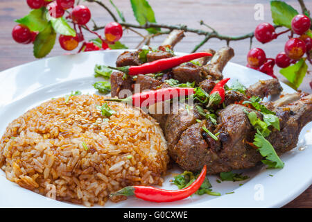 Nahaufnahme der gegrilltes Lammkotelett serviert mit Reis, mit würzigen roten Chili, Koriander, etc. Stockfoto