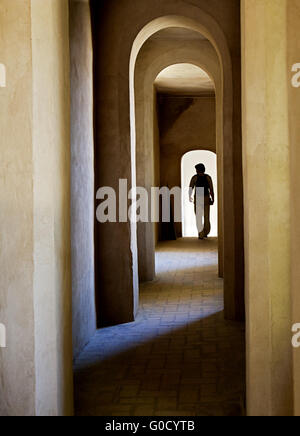 Torbogen in einer mittelalterlichen Burg in Spanien und eine Silhouette eines Touristen Stockfoto