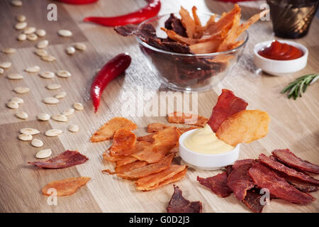 Fleischchips auf einem Teller mit Paprika Kürbis Samen und Pfeffer Stockfoto