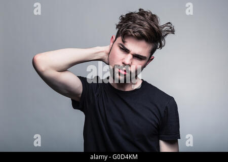 Schönen jungen Mann Zweifel auf grauem Hintergrund Stockfoto