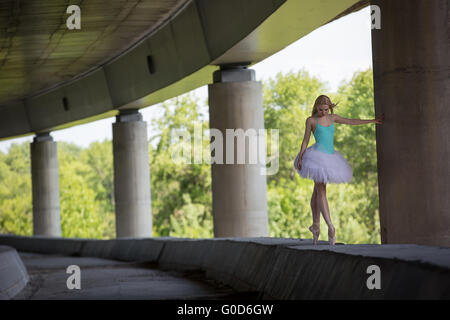 Anmutige Ballerina Tanz-Übungen auf eine Betonbrücke Stockfoto