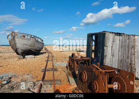Verlassenes Fischerboot und Winde am Kiesstrand von Dungeness, Kent England, Großbritannien. Die desolate Landschaft ist bei Fotografen beliebt Stockfoto
