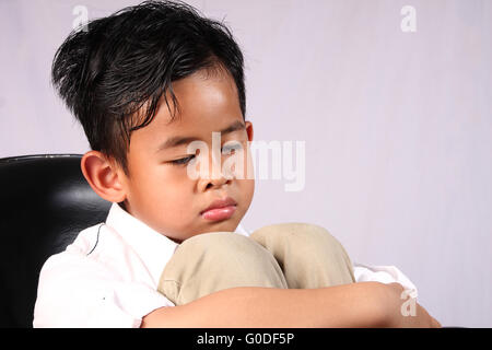 Porträt von traurig Asian Boy legte sein Gesicht auf die Knie Stockfoto