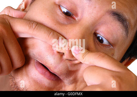 Asiatischer Mann Akne auf der Nase mit zwei Fingern zusammendrücken Stockfoto