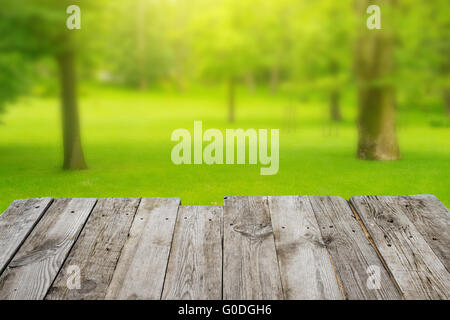 Blick vom Holztisch in den grünen Bokeh-Hintergrund Stockfoto