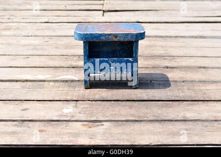 Alte kleine Holz- Blau angeln Stuhl allein auf hölzernen Fishing Pier. Kroatien, Podgora Stockfoto