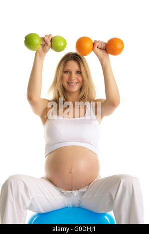 Schwangere beschäftigt sich mit Fitness Hanteln Obst Stockfoto