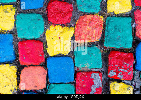 Alte bemalte Kopfsteinpflaster Hintergrund mit grass Stockfoto
