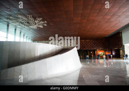 MEXIKO-STADT, Mexiko – die Hauptlobby des Nationalmuseums für Anthropologie (Museo Nacional de Antropología) zeigt modernistische mexikanische Architektur. Der Raum, der 1964 vom Architekten Pedro Ramírez Vázquez entworfen wurde, verfügt über ein dramatisches Innenraumvolumen und Tageslicht. Diese Eingangshalle dient als primäres Umlaufgebiet für die umfangreichen archäologischen und anthropologischen Sammlungen des Museums. Stockfoto