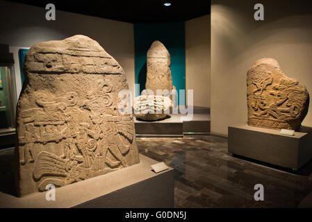 Nationalmuseum für Anthropologie Aztekenschnitzereien Mexiko-Stadt // MEXIKO-STADT, Mexiko — Aztekenschnitzereien werden im Nationalmuseum für Anthropologie ausgestellt, Mexikos wichtigste Institution, die dem präkolumbianischen Erbe des Landes gewidmet ist. Das Museum beherbergt eine der weltweit umfangreichsten Sammlungen mesoamerikanischer Artefakte, darunter bedeutende Stücke aus Azteken, Maya, Olmec und anderen indigenen Zivilisationen. Die 1964 gegründete Institution dient als nationales Repository für archäologische und ethnographische Materialien, die Tausende von Jahren mexikanischer Geschichte umfassen. Die Sammlung des Museums Stockfoto