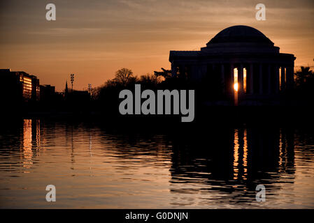 WASHINGTON, D.C., Vereinigte Staaten – das Jefferson Memorial hat eine dramatische Silhouette vor der aufgehenden Sonne über dem Tidal Basin in Washington, D.C. dieser ikonische Blick fängt die unverwechselbare Kuppel und Kolonnade des neoklassizistischen Monuments in krassem Kontrast zum goldenen Licht der Morgendämmerung ein. Stockfoto