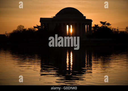 WASHINGTON, D.C., Vereinigte Staaten – das Jefferson Memorial hat eine dramatische Silhouette vor der aufgehenden Sonne über dem Tidal Basin in Washington, D.C. dieser ikonische Blick fängt die unverwechselbare Kuppel und Kolonnade des neoklassizistischen Monuments in krassem Kontrast zum goldenen Licht der Morgendämmerung ein. Stockfoto