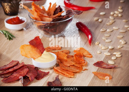 Fleischchips auf einem Teller mit Paprika Kürbis Samen und Pfeffer Stockfoto