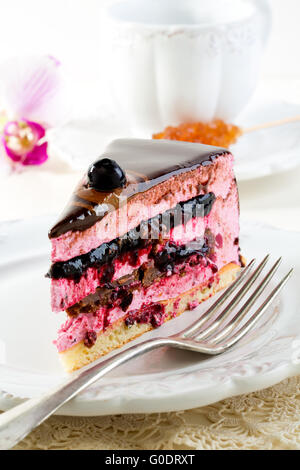 Stück Kuchen mit Souffle und schwarze Johannisbeere Gelee auf einem weißen Teller. Stockfoto