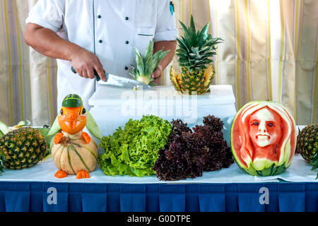 Tabelle mit Obst Schnitzereien und Teilansicht eines Co Stockfoto