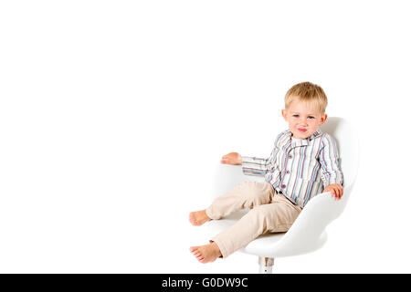 Junge im Studio auf einem weißen Hintergrund im Stuhl textfreiraum erschossen Stockfoto