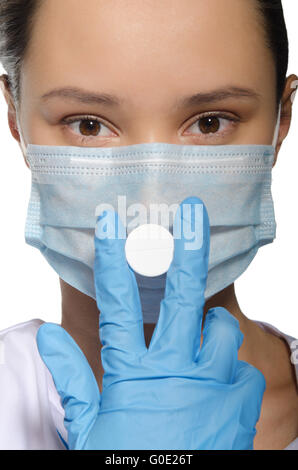 Arzt eine Pille in seiner Maske Mund geschlossen halten Stockfoto