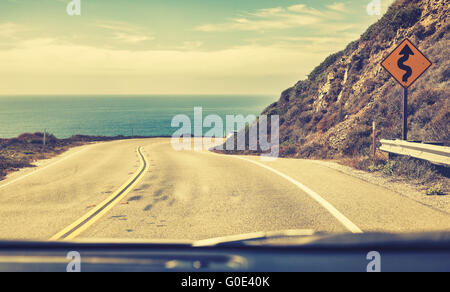 Alte Film stilisierte Straße gesehen durch die Windschutzscheibe eines fahrenden Autos, Pacific Coast Highway oder State Route 1, Kalifornien, USA. Stockfoto