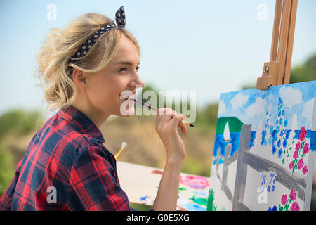 Schöne blonde Frau Künstler malt ein buntes Bild. Stockfoto