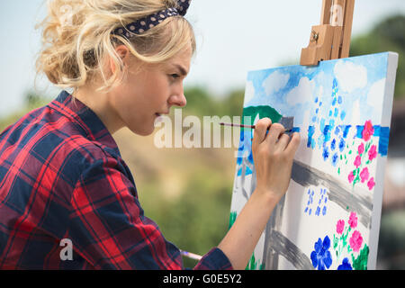 Schöne blonde Frau Künstler malt ein buntes Bild. Stockfoto