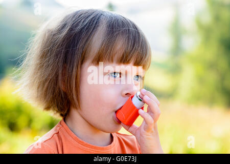 Kleines Mädchen mit Inhalator an einem sonnigen Tag Stockfoto