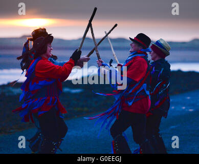 „RAG Bag Morris“ zum 1. Mai auf dem Damm zur Heiligen Insel Lindisfarne, Northumberland. Jedes Jahr tanzen sie bei Sonnenaufgang am 1. Mai an einem anderen Ort im Norden von Northumberland oder den Scottish Borders. Stockfoto