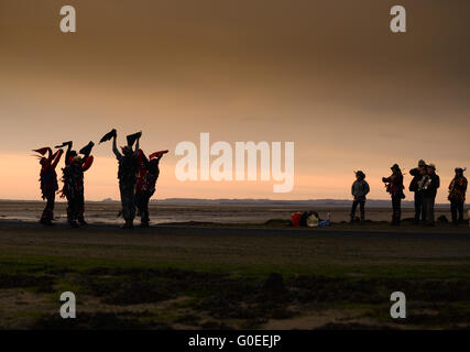 „RAG Bag Morris“ zum 1. Mai auf dem Damm zur Heiligen Insel Lindisfarne, Northumberland. Jedes Jahr tanzen sie bei Sonnenaufgang am 1. Mai an einem anderen Ort im Norden von Northumberland oder den Scottish Borders. Stockfoto