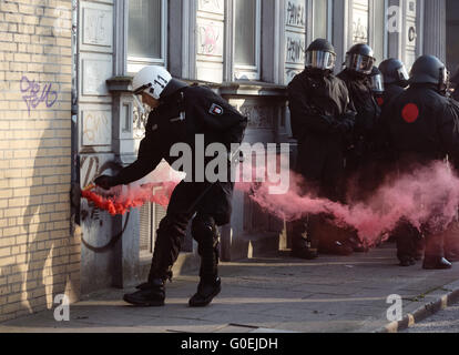 Hamburg, Deutschland. 1. Mai 2016. Mitglied der deutschen Polizei entschärft eine Fackel während der revolutionären Maikundgebung in Hamburg, Deutschland, 1. Mai 2016. Foto: MARKUS SCHOLZ/Dpa/Alamy Live News Stockfoto