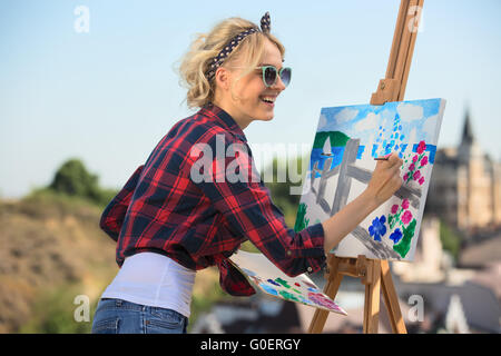 Schöne blonde Frau Künstler malt ein buntes Bild. Stockfoto