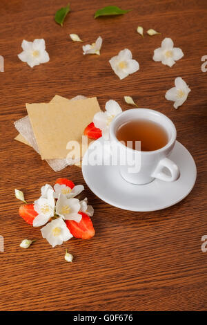 weiße Tasse grüner Tee. Jasminblüten mit Erdbeer-Hälften. Textur für schreiben leer. Still-Leben Stockfoto