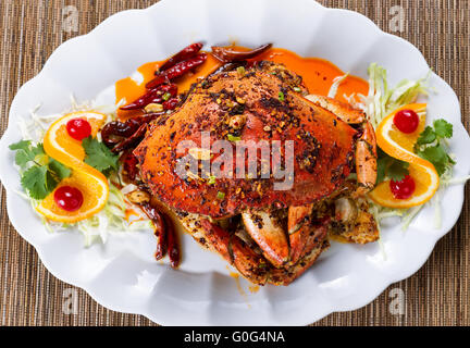 Ganze gekochte Dungeness Krabbe mit Erdnuss-Sauce und Gewürze auf weißem Teller bereit, Essen Stockfoto