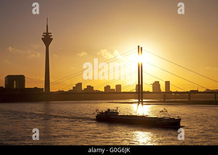 Der Rhein mit Frachtschiff, Stadttor, dem Rheinturm und Rheinkniebruecke, Düsseldorf, Deutschland Stockfoto