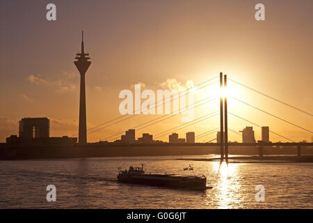 Der Rhein mit Frachtschiff, Stadttor, dem Rheinturm und Rheinkniebruecke, Düsseldorf, Deutschland Stockfoto