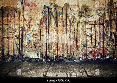 Grunge Betonwand mit zufälligen Graffiti und Boden Stockfoto