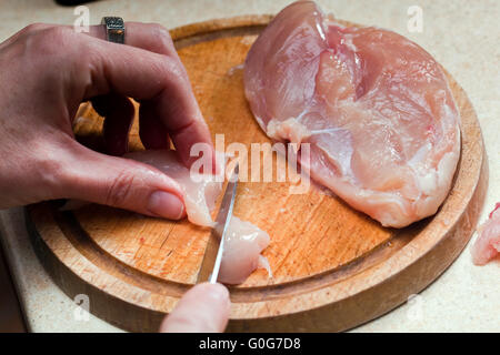 Schneiden in Scheiben auf einem Holzbrett treffen. Frau Hände hautnah. Stockfoto