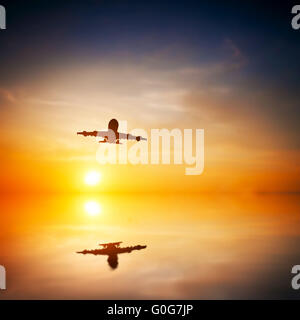 Flugzeug abheben bei Sonnenuntergang. Silhouette eines Passagiers oder Frachtflugzeuge, Fluggesellschaft Stockfoto