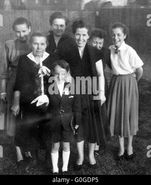 50er Jahre, Religion, Christentum, Erstkommunion, Kinder-Kommunion, Kommunion Kind mit Kommunion Kerze und Prayerbook, Boy 8 bis 10 Jahre, Gruppenbild mit der Familie, Mutter, Oma, Schwester, Mädchen Cousine, Tante, Werner, Frieda, Maria, Doris, Katharina, Christel, Inge Stockfoto